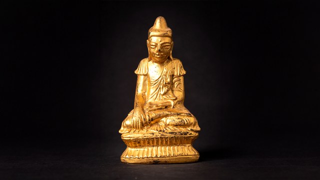 Gilded Buddha figure in darkness