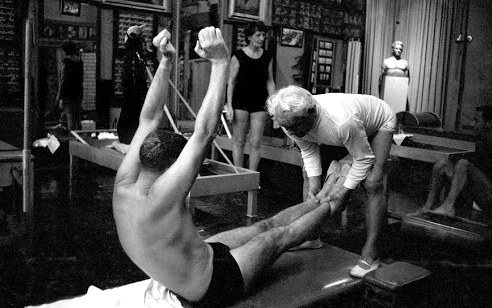Archivaufnahme: Joseph Pilates korrigiert einen Schüler in seinem New Yorker Studio