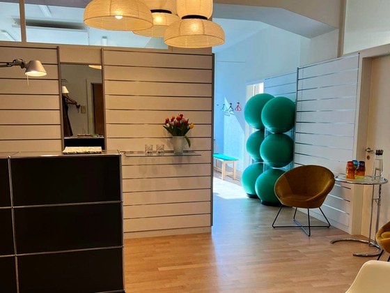 Eingangsbereich des Pilates-Studios mit Holzboden und Pendelleuchten