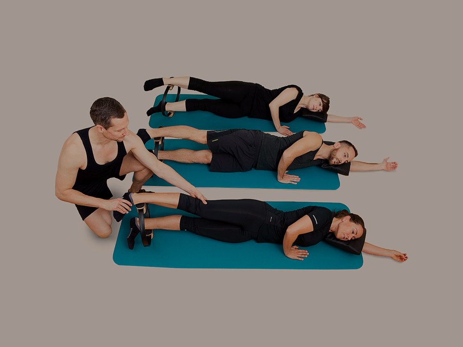 Christoph Klaus korrigiert eine Pilates-Kleingruppe auf der Matte im Studio Zürich Oerlikon