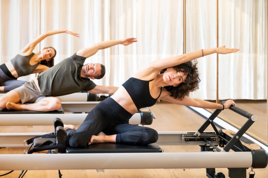 Warum Pilates ganz oben auf der Liste Ihrer Vorsätze fürs 2023 stehen sollte! 4 group people doing mermaid exercise pilates reformers fitness center 126745 3369